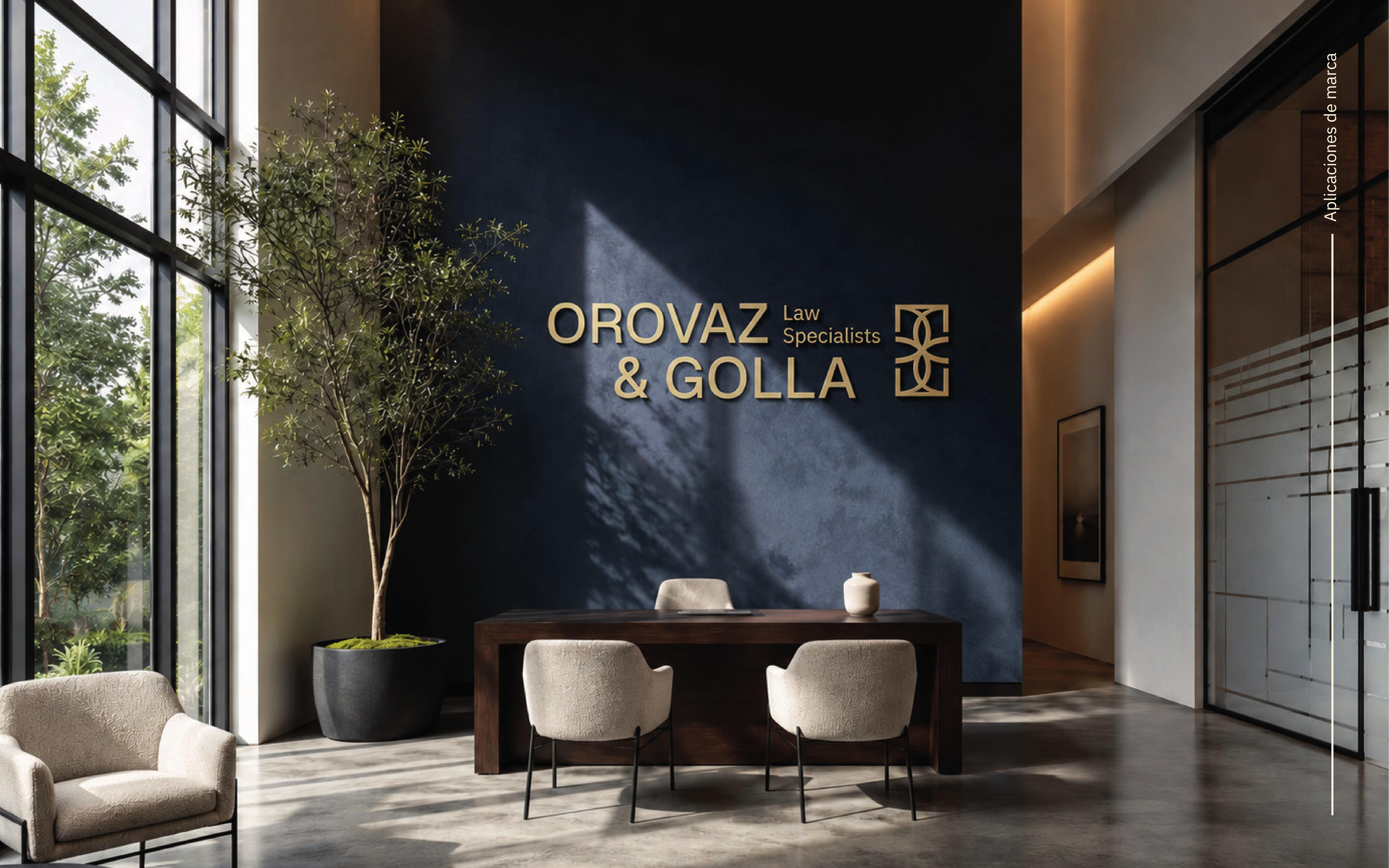 Recepción moderna con muro azul, logotipo dorado Orovaz & Golla, escritorio y sillas beige.